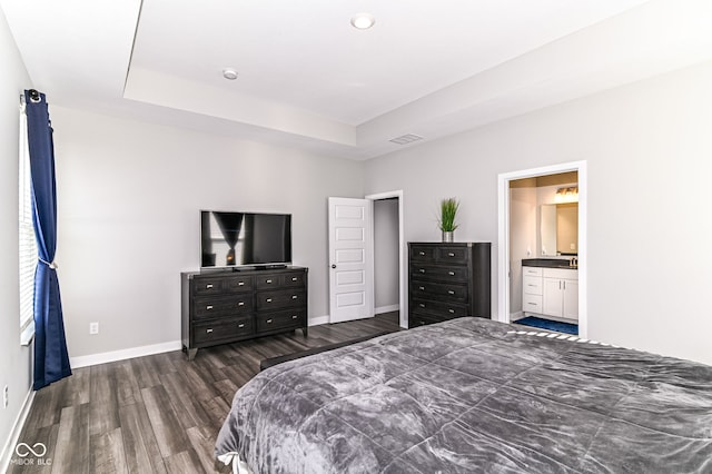 bedroom featuring a tray ceiling, visible vents, dark wood finished floors, and baseboards