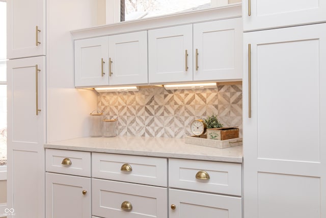 bar featuring white cabinetry, light stone counters, and tasteful backsplash