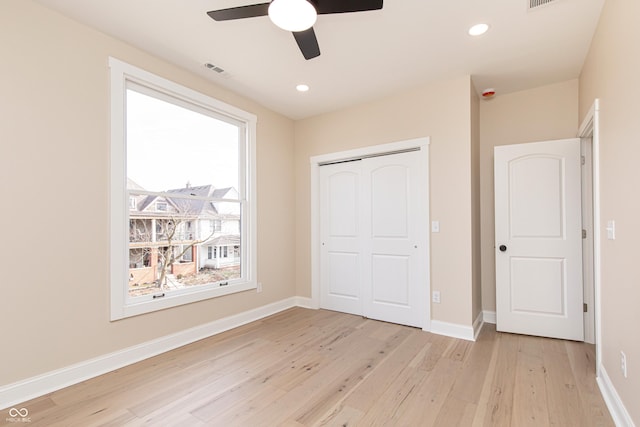 unfurnished bedroom featuring ceiling fan, a closet, and light wood-type flooring