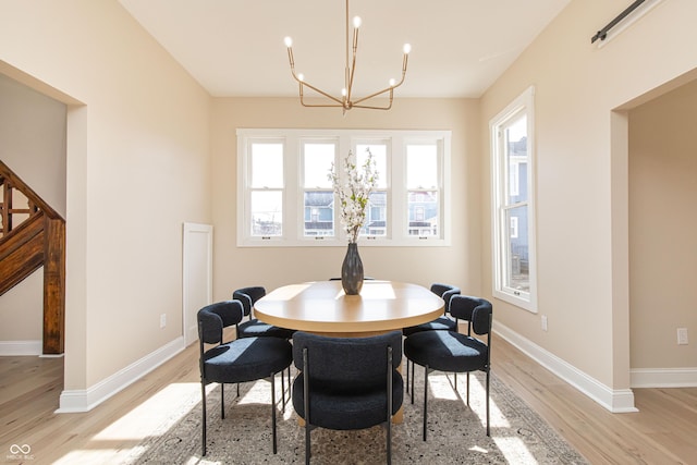 dining area with a chandelier and light hardwood / wood-style flooring