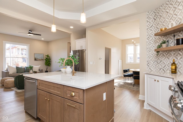 kitchen featuring sink, decorative light fixtures, a wealth of natural light, stainless steel appliances, and white cabinets