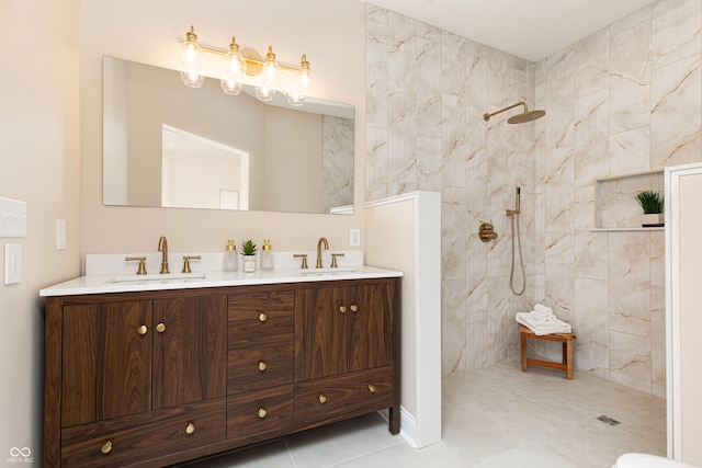 bathroom with vanity, a tile shower, and tile patterned floors