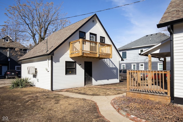 rear view of property featuring a wooden deck and a balcony