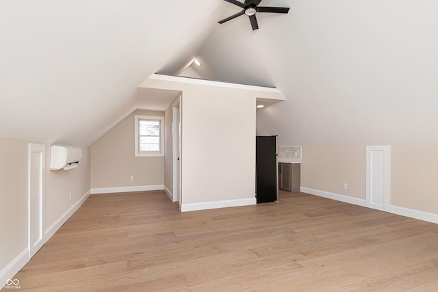 bonus room with vaulted ceiling, a wall unit AC, ceiling fan, and light wood-type flooring