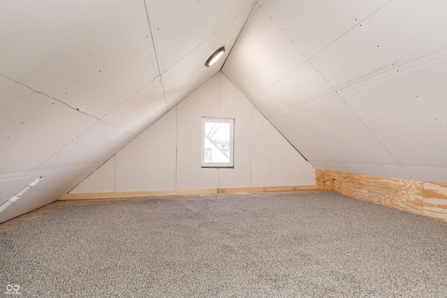 bonus room with vaulted ceiling and carpet