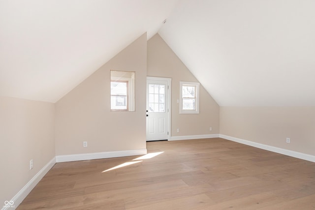 bonus room with lofted ceiling and light hardwood / wood-style floors