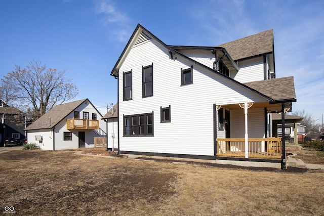 rear view of property with a porch and a yard