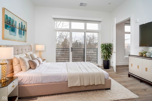 bedroom with light wood finished floors, baseboards, and visible vents