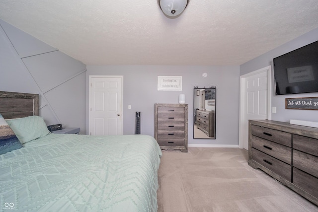 bedroom with light colored carpet and a textured ceiling