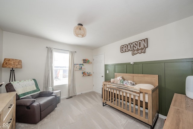 bedroom featuring a crib and light colored carpet