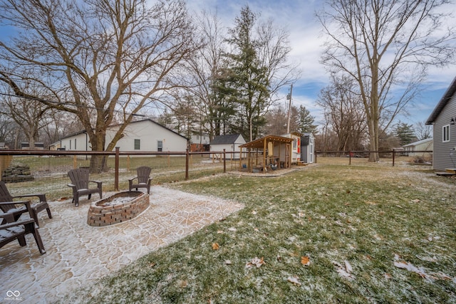 view of yard with a fire pit, a patio, and a storage unit