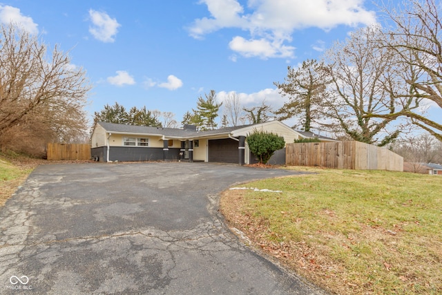 ranch-style house with a garage and a front lawn