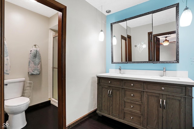 bathroom with a shower with door, vanity, hardwood / wood-style floors, and toilet