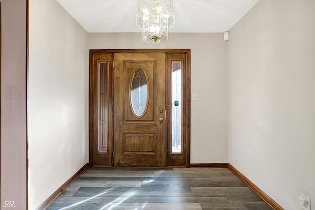 foyer entrance featuring an inviting chandelier and dark hardwood / wood-style flooring