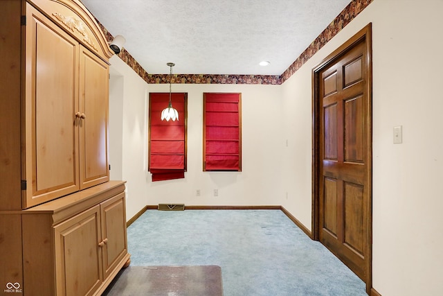 carpeted empty room featuring a textured ceiling