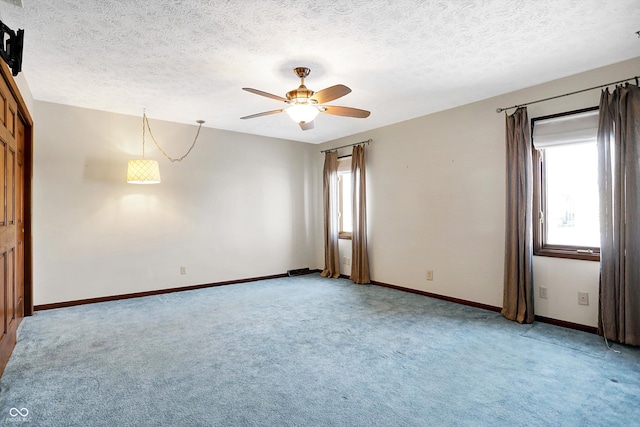 carpeted spare room with ceiling fan and a textured ceiling