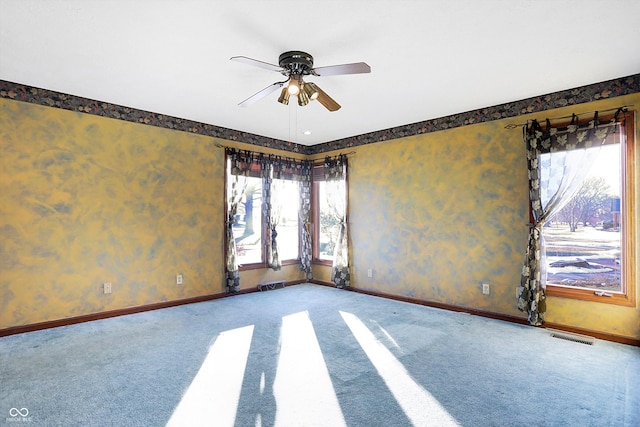 carpeted spare room featuring ceiling fan