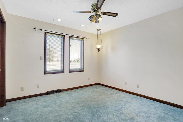 carpeted empty room with ceiling fan and a textured ceiling