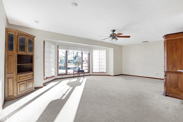 unfurnished living room with light carpet and ceiling fan