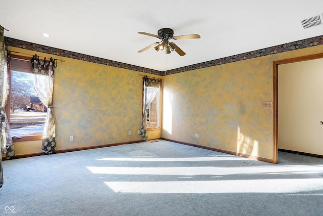 carpeted empty room featuring ceiling fan