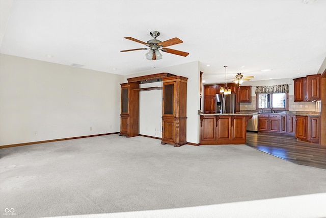 unfurnished living room featuring light colored carpet and ceiling fan