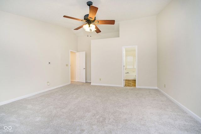 unfurnished bedroom with light carpet, ceiling fan, high vaulted ceiling, and ensuite bath