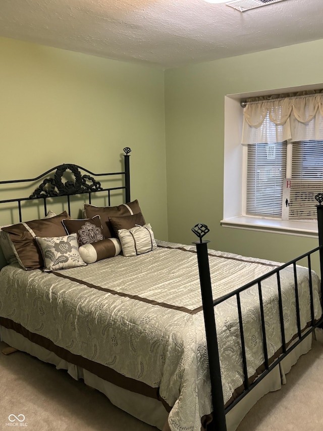 bedroom with carpet floors and a textured ceiling