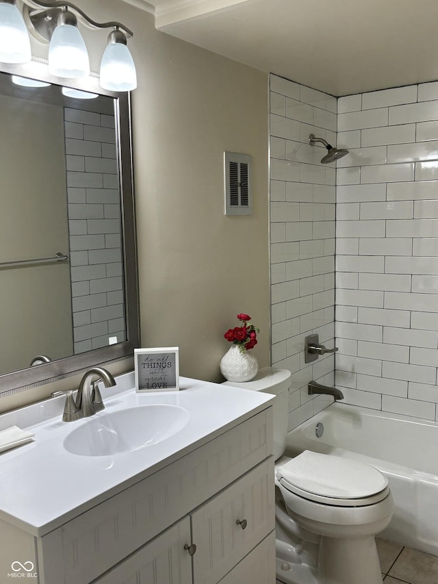 full bathroom with tile patterned flooring, vanity, tiled shower / bath combo, and toilet