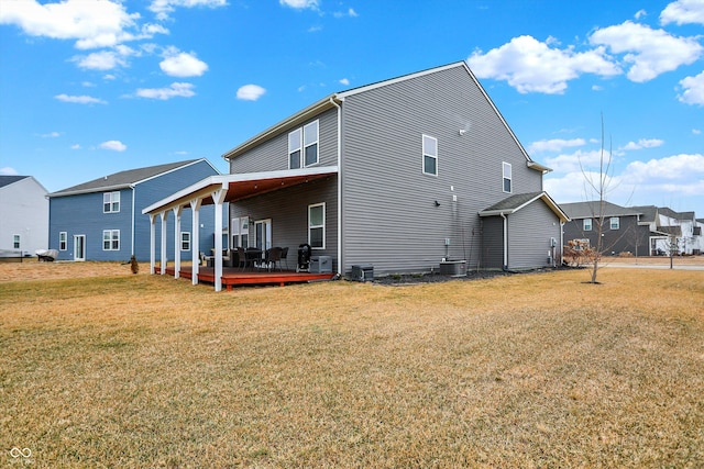 back of property with a yard, cooling unit, and a deck