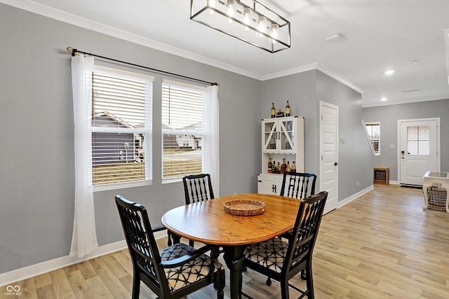 dining area with crown molding, a wealth of natural light, and light hardwood / wood-style flooring