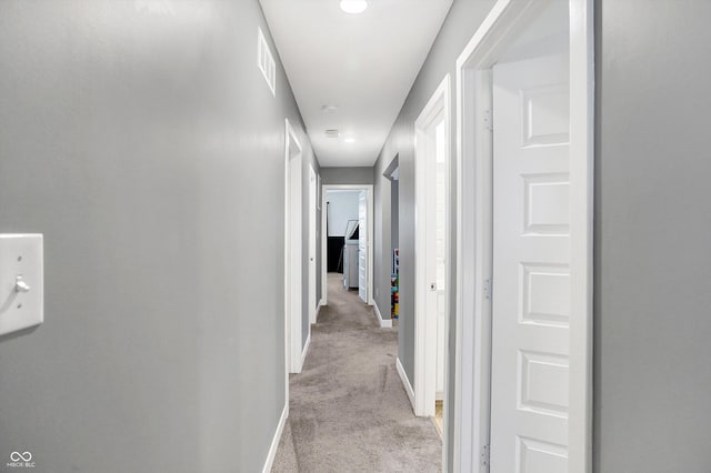 hall featuring light colored carpet