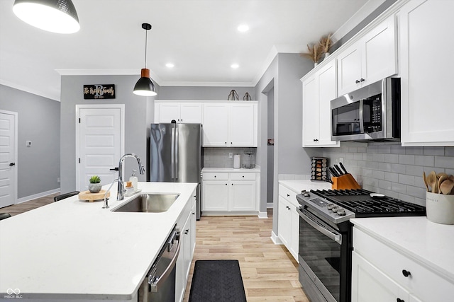 kitchen with sink, white cabinetry, a center island with sink, pendant lighting, and stainless steel appliances