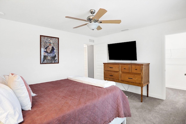 carpeted bedroom featuring a spacious closet and ceiling fan