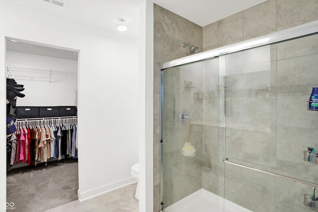 bathroom featuring walk in shower and toilet