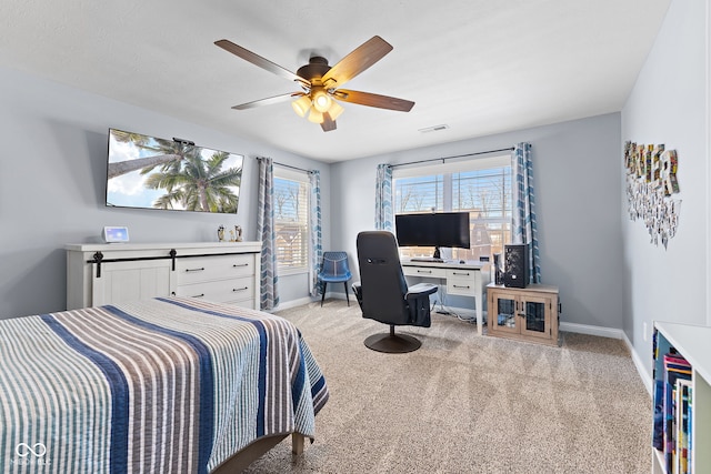 bedroom featuring a ceiling fan, visible vents, light carpet, and baseboards