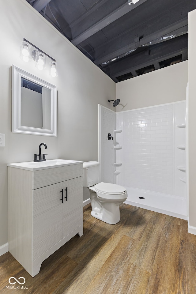 full bath featuring toilet, a shower, wood finished floors, and vanity