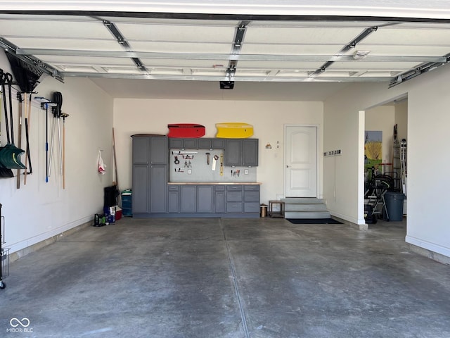 garage with baseboards and a garage door opener