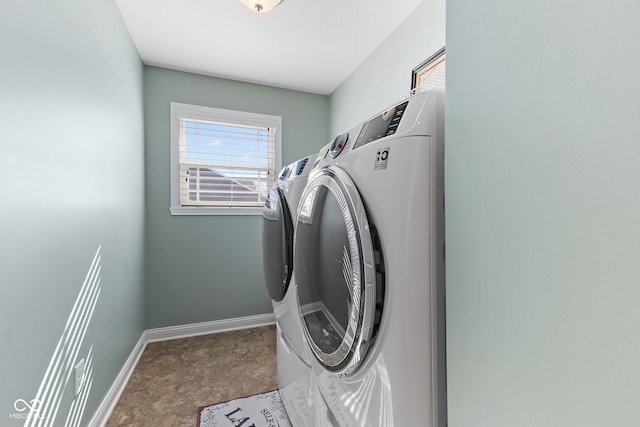 laundry area with laundry area, independent washer and dryer, and baseboards