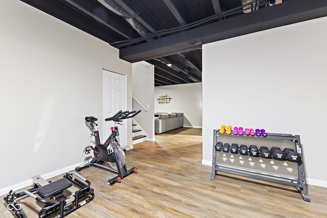 exercise area featuring baseboards and wood finished floors