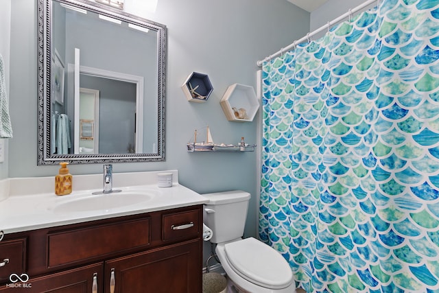 bathroom with curtained shower, vanity, and toilet