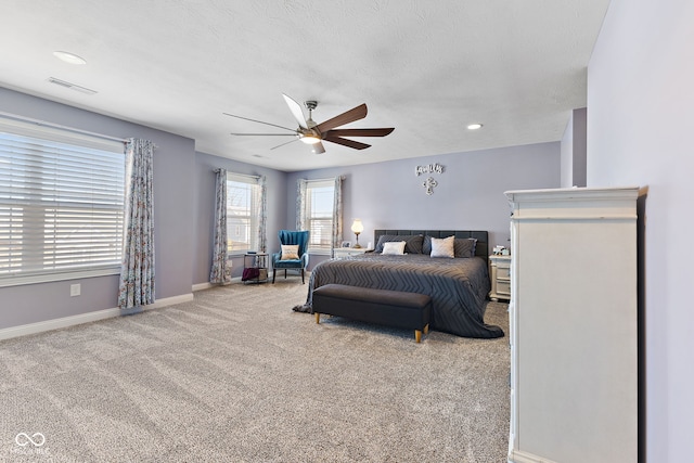 bedroom with light carpet, visible vents, baseboards, ceiling fan, and a textured ceiling