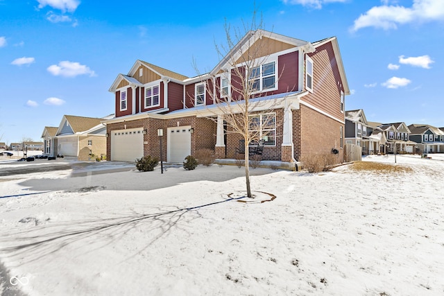 view of front of home with a garage, a residential view, and brick siding