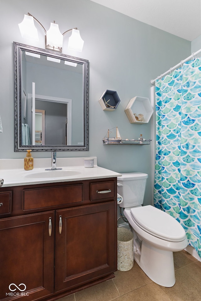 bathroom featuring tile patterned flooring, vanity, and toilet