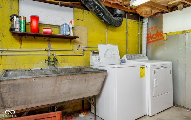 clothes washing area featuring laundry area, separate washer and dryer, and a sink