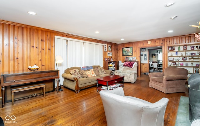 living room with wooden walls, wood finished floors, and recessed lighting