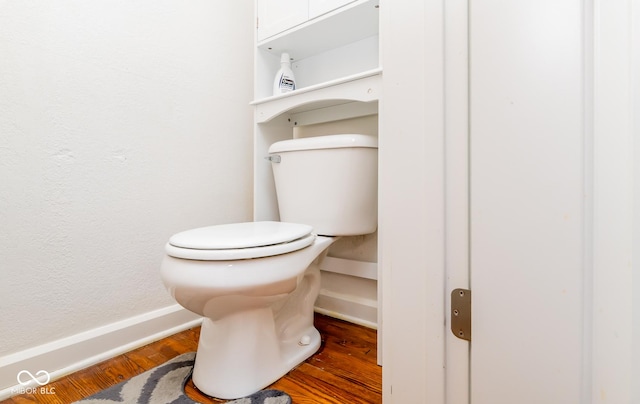 bathroom featuring baseboards, toilet, and wood finished floors