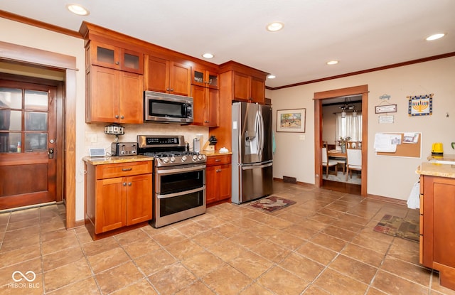 kitchen featuring backsplash, appliances with stainless steel finishes, glass insert cabinets, ornamental molding, and light stone countertops