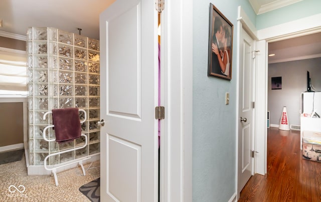 hallway featuring ornamental molding, baseboards, and wood finished floors