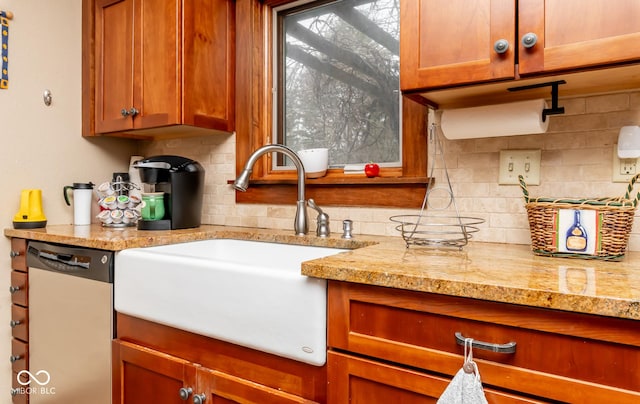 kitchen featuring a sink, tasteful backsplash, light stone counters, and dishwasher