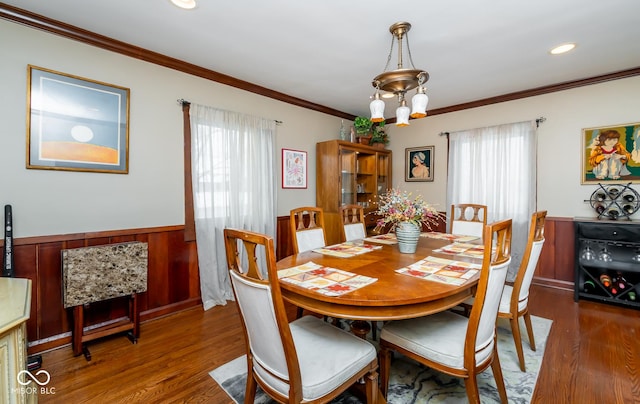 dining space featuring ornamental molding, dark wood-style flooring, wainscoting, and recessed lighting